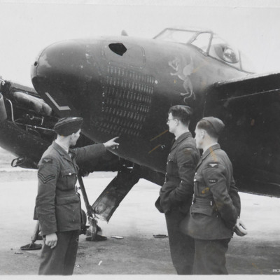 Three airmen by the nose of a damaged Mosquito